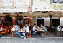 Lidé sedí na zahrádce restaurace.
