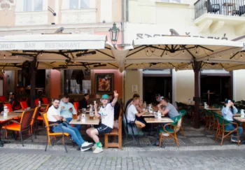 Lidé sedí na zahrádce restaurace.