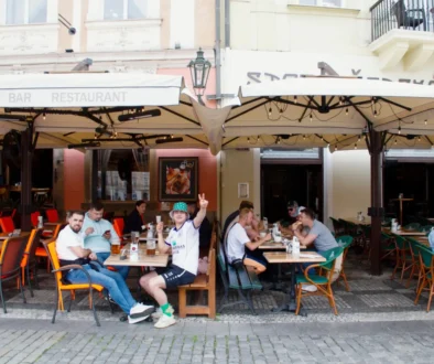 Lidé sedí na zahrádce restaurace.