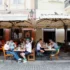 Lidé sedí na zahrádce restaurace.