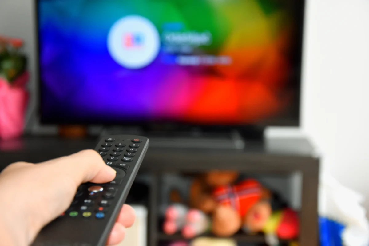 Člověk ovladačem míří na TV.