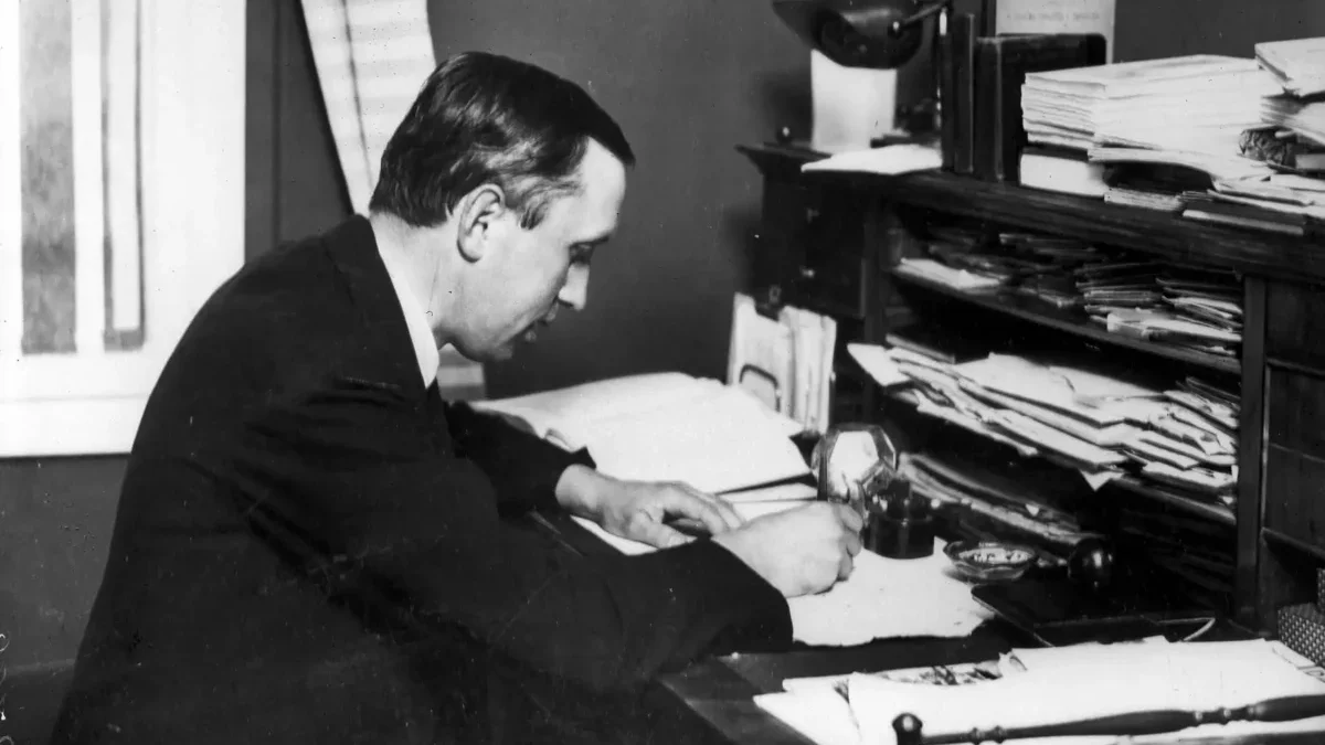 Karel čapek sedí u stolu a píše.