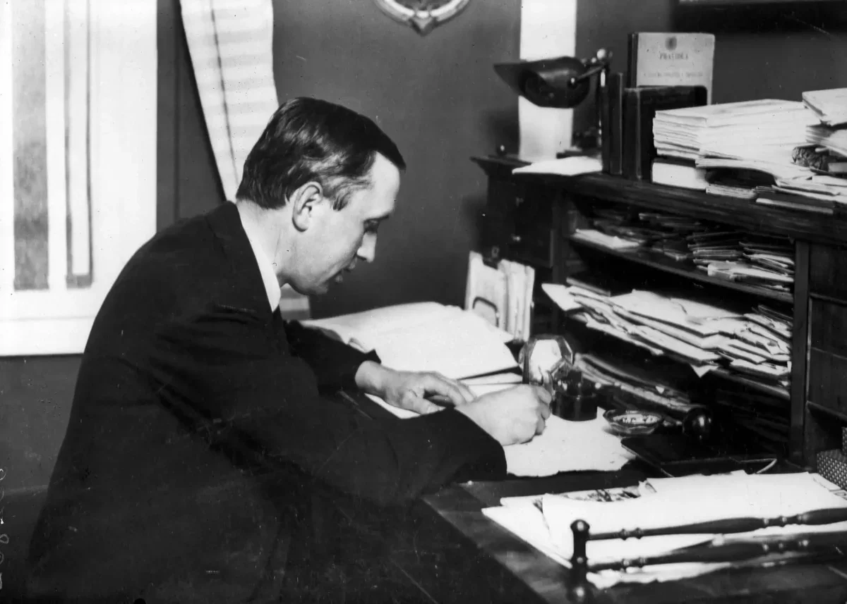 Karel čapek sedí u stolu a píše.