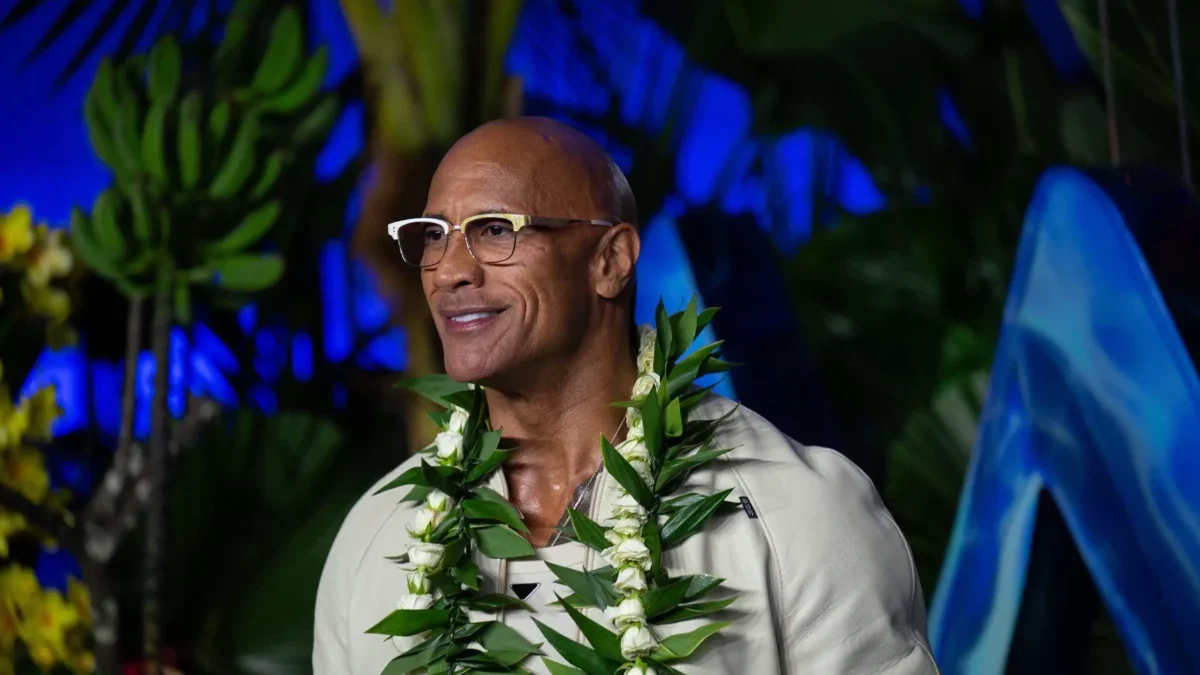 Dwayne Johnson má kolem krku věnec.