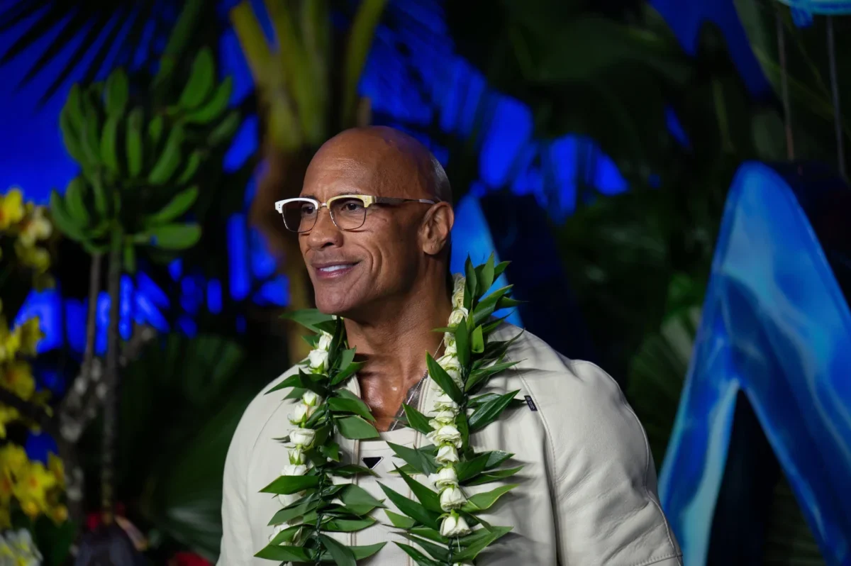 Dwayne Johnson má kolem krku věnec.
