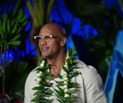 Dwayne Johnson má kolem krku věnec.
