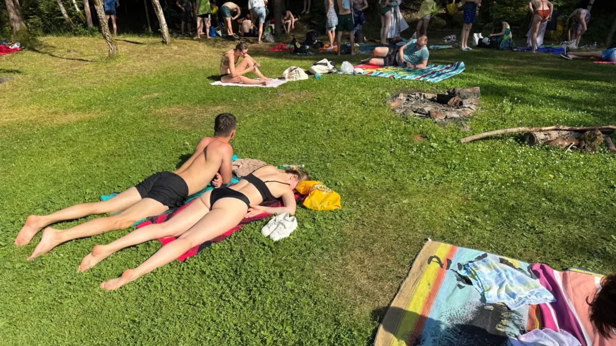 Lidé leží na trávníku.