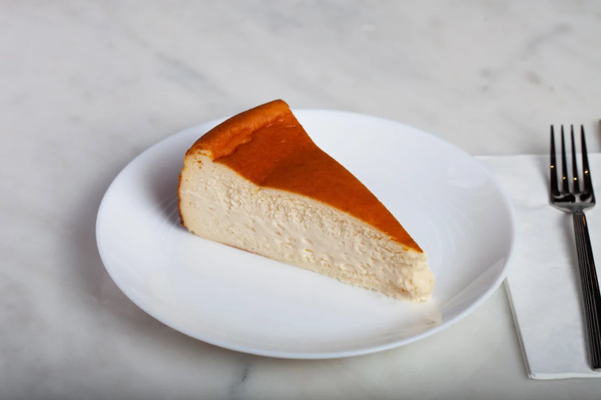 Na talíři je porce cheesecaku.