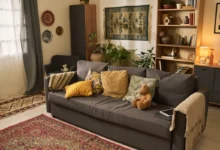 Cozy living room with a gray sofa, mustard and patterned cushions, and a woven rug on the floor.
