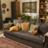 Cozy living room with a gray sofa, mustard and patterned cushions, and a woven rug on the floor.