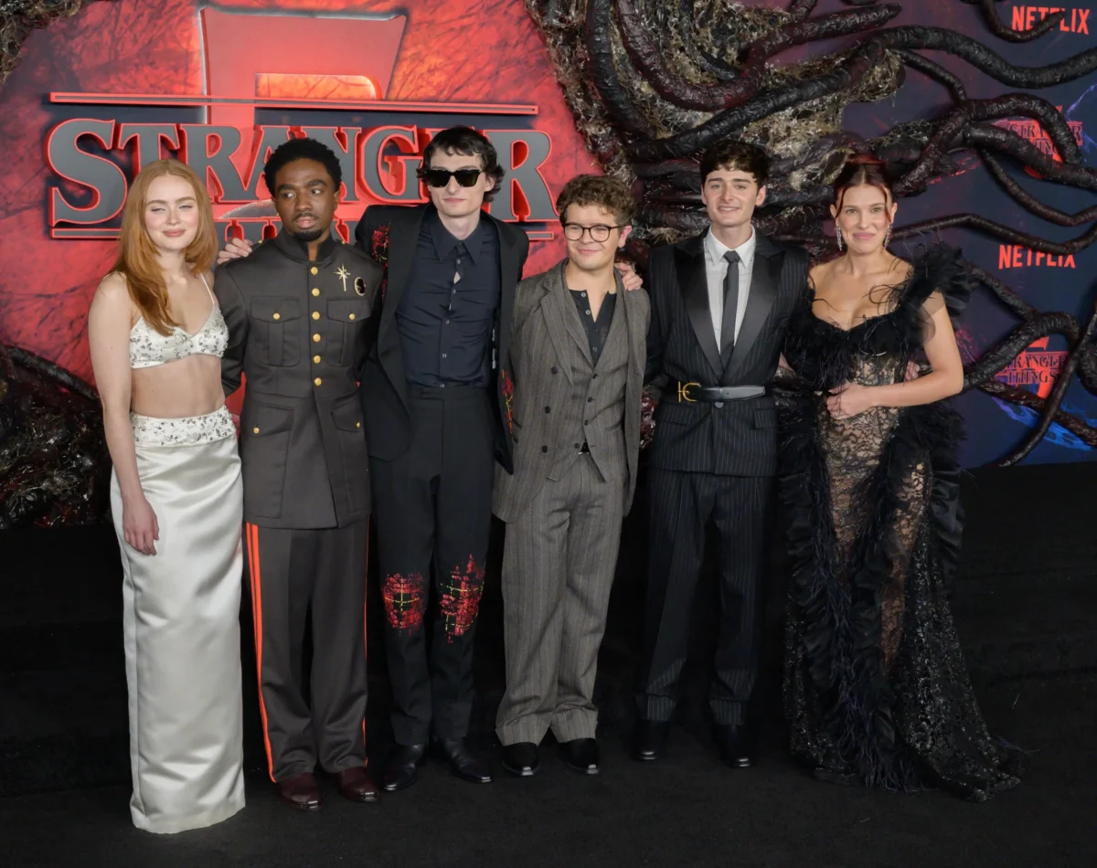 Hlavní roli si zahrála Eleven ze seriálu Stranger Things. Zdroj: Shutterstock | TVGURU.cz Lidé ve společenských šatech držící se kolem pasu