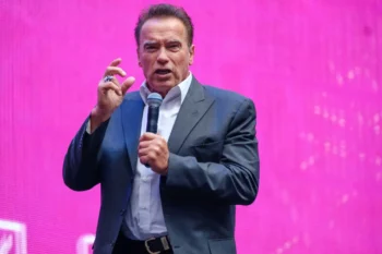 Arnold Schwarzenegger drží mikrofon.