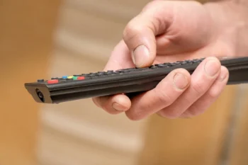 detailní pohled na ruku s televizním ovladačem