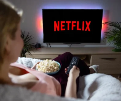 paní s popcornem sedí na gauči a kouká na netflix