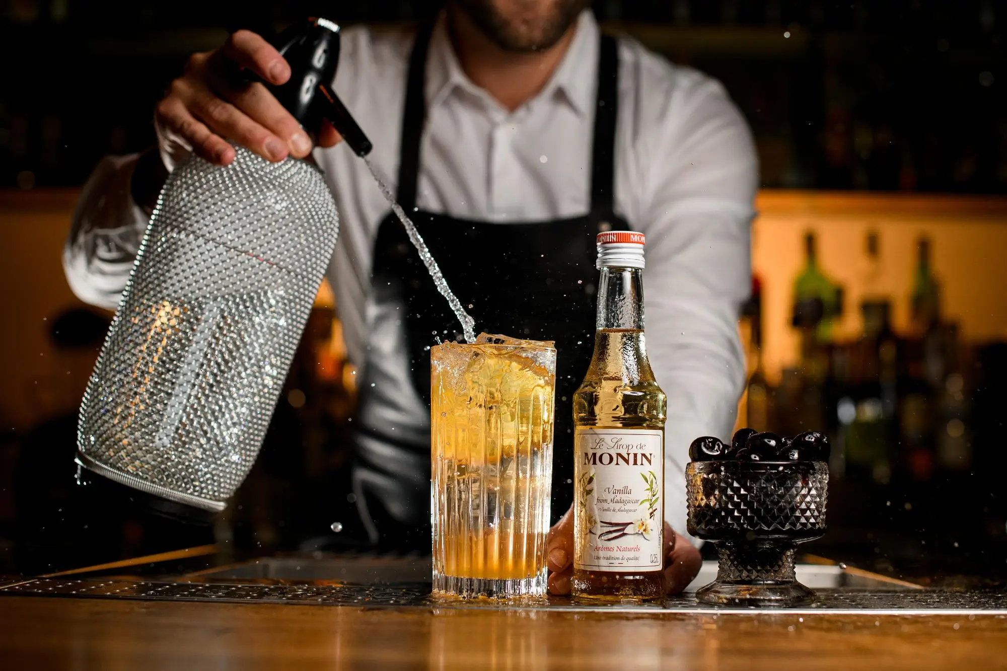 Pamatujete, jak se kdysi vyráběla domácí sodovka? | TVGURU.cz Muž stříká sodu do drinku.