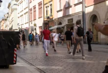 Lidé se procházejí po polské ulici.