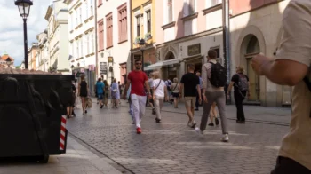 Lidé se procházejí po polské ulici.