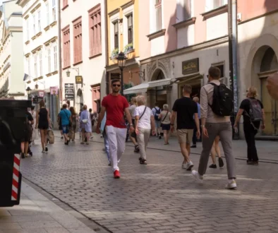 Lidé se procházejí po polské ulici.