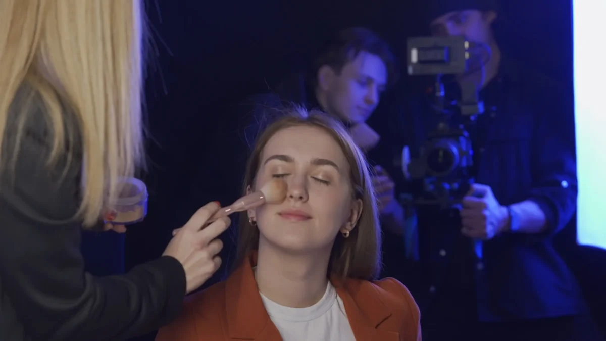 Vyživená pokožka dokáže zamaskovat drobné vrásky. Zdroj: Shutterstock | TVGURU.cz Sedící žena, které druhá žena nanáší make-up.