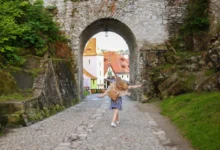 Žena se prochází uličkou v Krumlově.