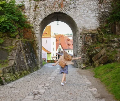 Žena se prochází uličkou v Krumlově.