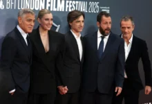 George Clooney stojí vedle lidí.
