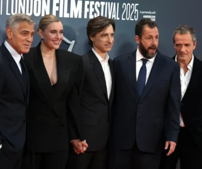 George Clooney stojí vedle lidí.