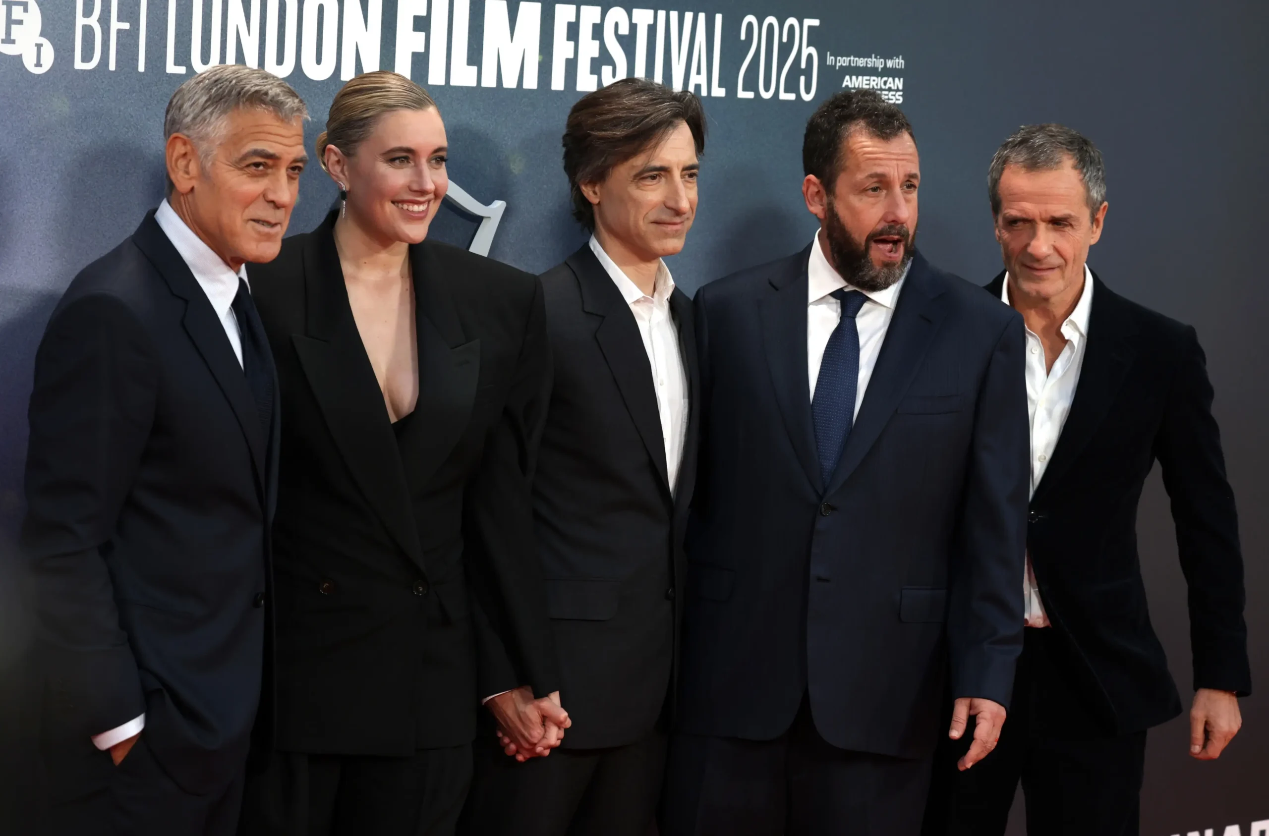 George Clooney stojí vedle lidí.