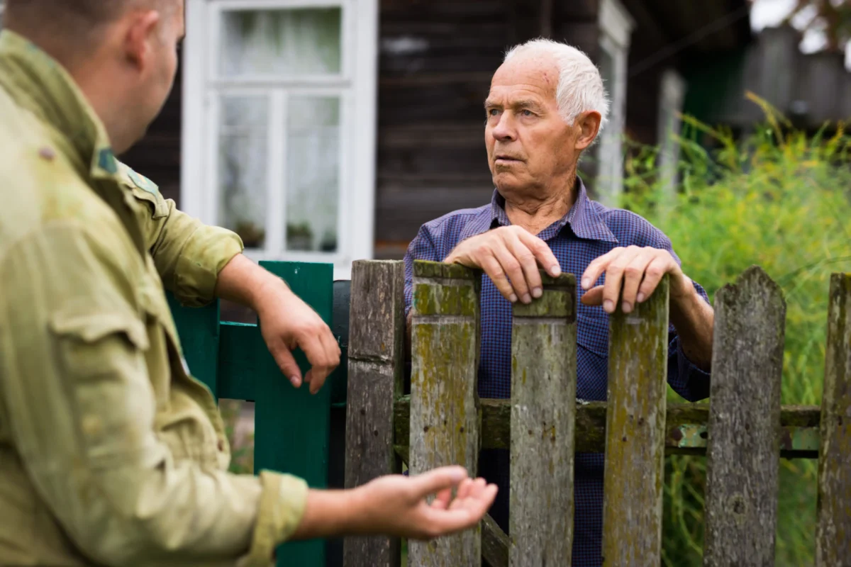 Mnoho z nás ani neví, vedle koho vlastně bydlí. Zdroj: Shutterstock | TVGURU.cz Dva muži povídající si přes plot