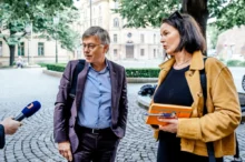 Hynek Chudárek postává vedle ženy a mikrofonu.