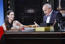 Prostředí televizní talk show s usmívající se hostující ženou a moderátorem u stolu, na stole viditelný chléb, pečivo a nápoje. V popředí s Janem Krausem