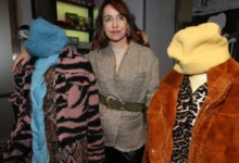 Žena stojící mezi figurínami s oblečením