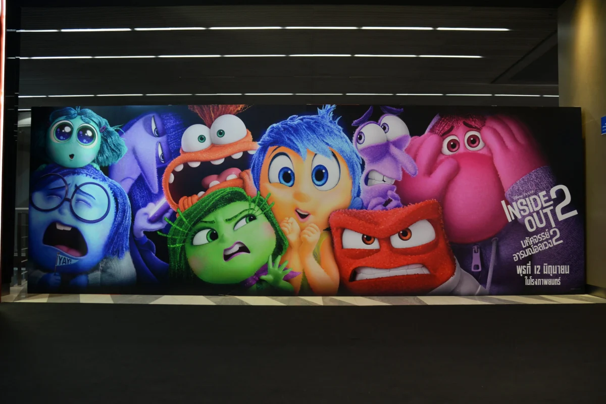 shutterstock_2491902377 1 | TVGURU.cz Colorful Inside Out 2 movie poster on a wall, showing several exaggerated emotion characters in bright colors as a group portrait.