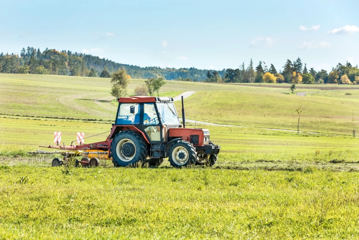 český starý červený traktor s pluhem na poli