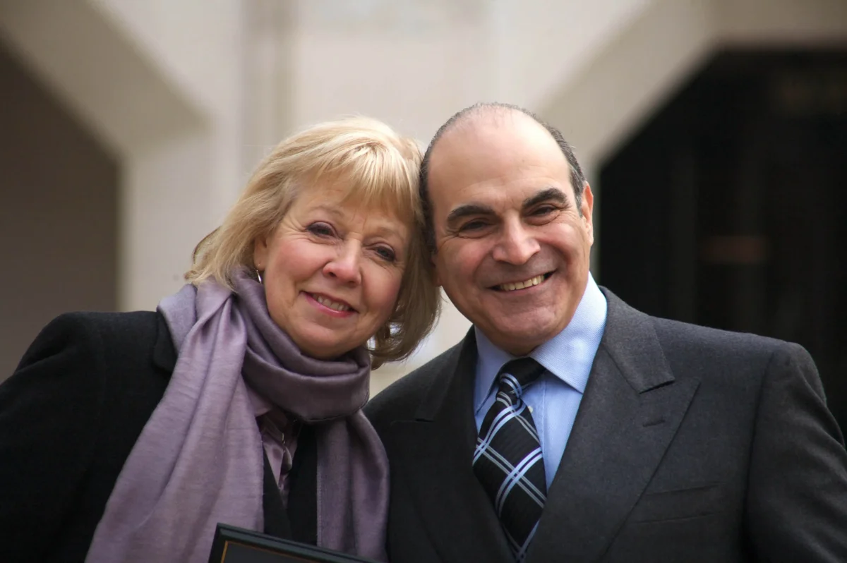 David Suchet stojí vedle ženy.