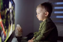 dítě sedící před televizí