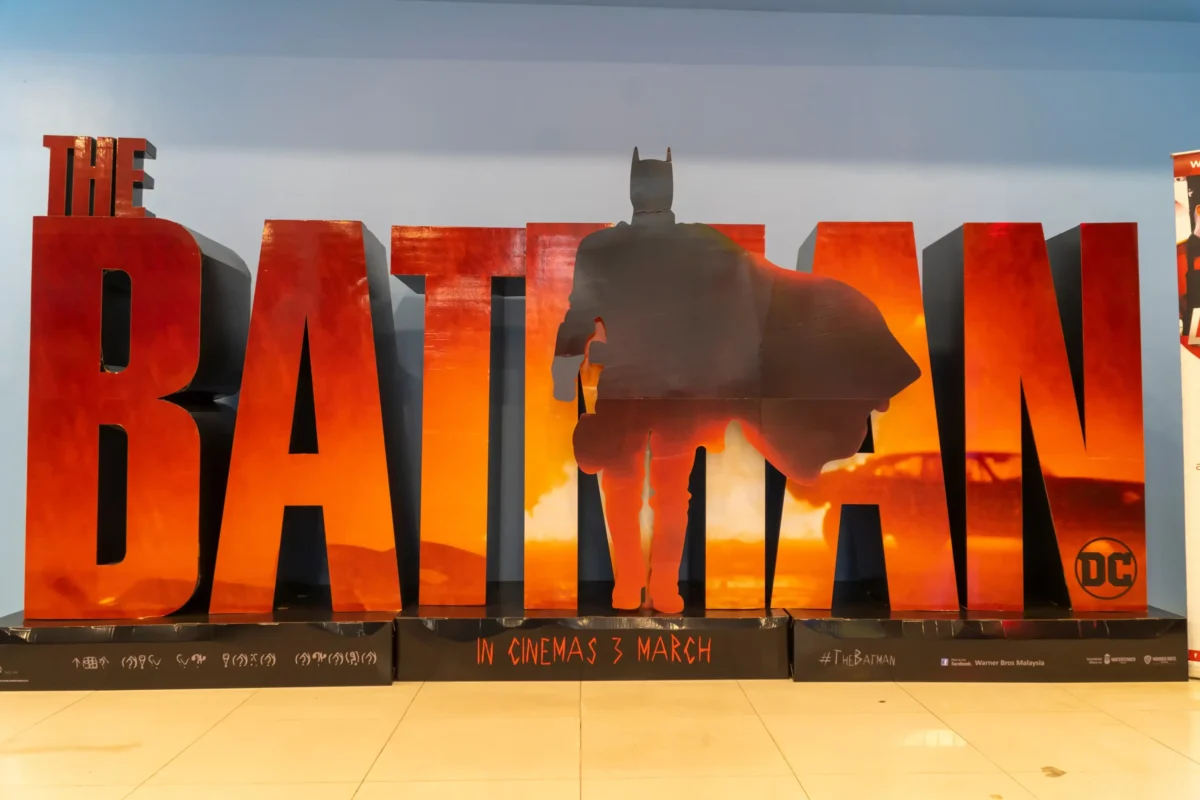 shutterstock_2134539155-změněno-na-3000x2000 | TVGURU.cz Velký červený nápis „BATMAN“ se siluetou Batmana vpředu; dole text uvedení do kina s nápisem „V kinech“ a datem/daty uvedení.