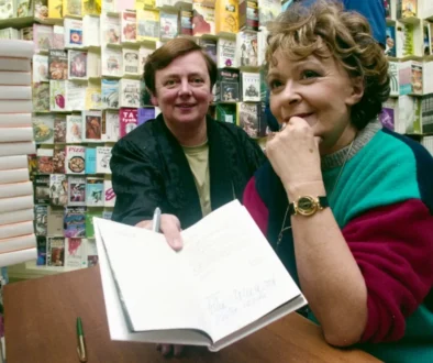 Žena s knihou a za ní sedící muž