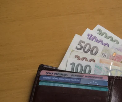 Z peněženky čouhají bankovky.