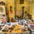 Cluttered vintage workshop with film reels, projectors, and wooden cabinets against yellow walls with retro posters and green trim patterns.