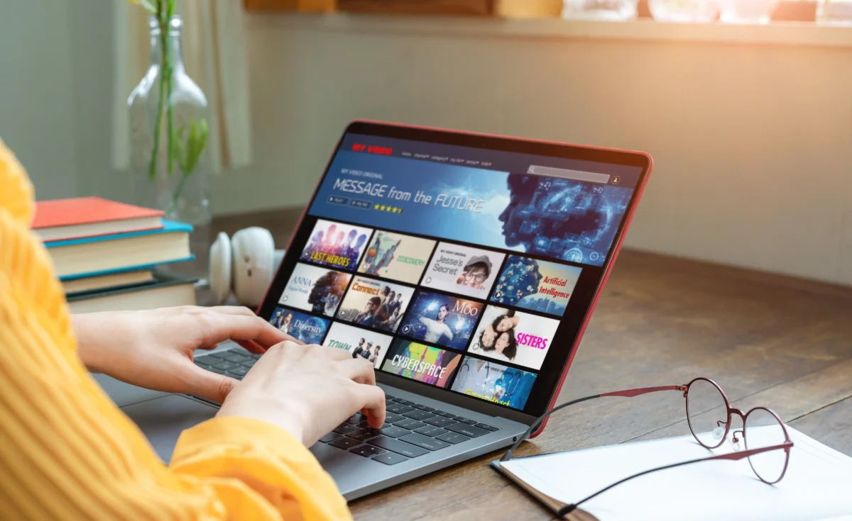 Odhlásit se z Netflixu na televizi můžete i na dálku. Zdroj: Shutterstock | TVGURU.cz Ruce pracující na notebooku s Netflixem