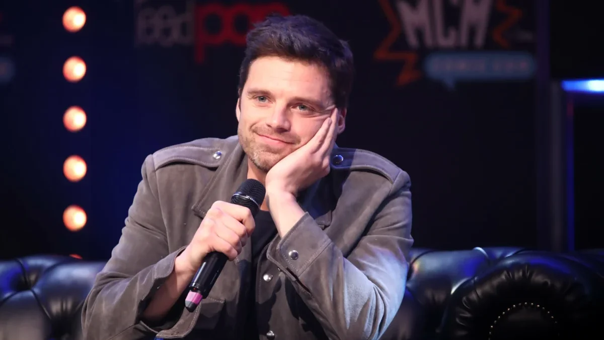 Sebastian Stan sedí a podpírá si hlavu.