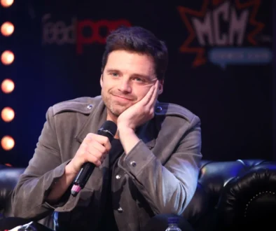 Sebastian Stan sedí a podpírá si hlavu.