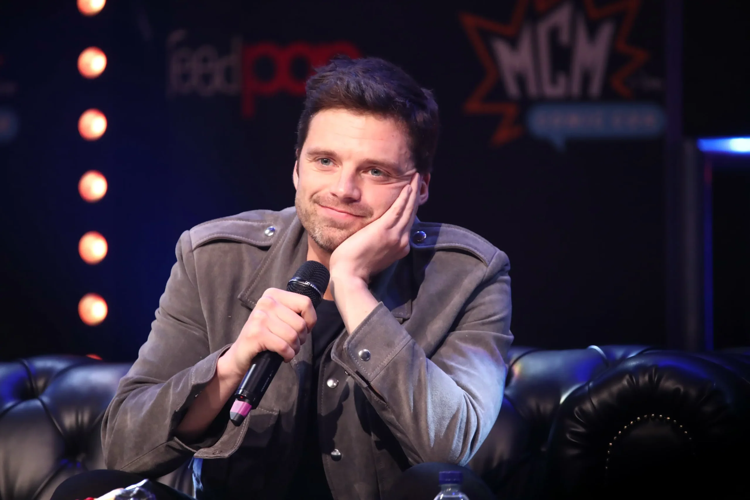 Sebastian Stan sedí a podpírá si hlavu.