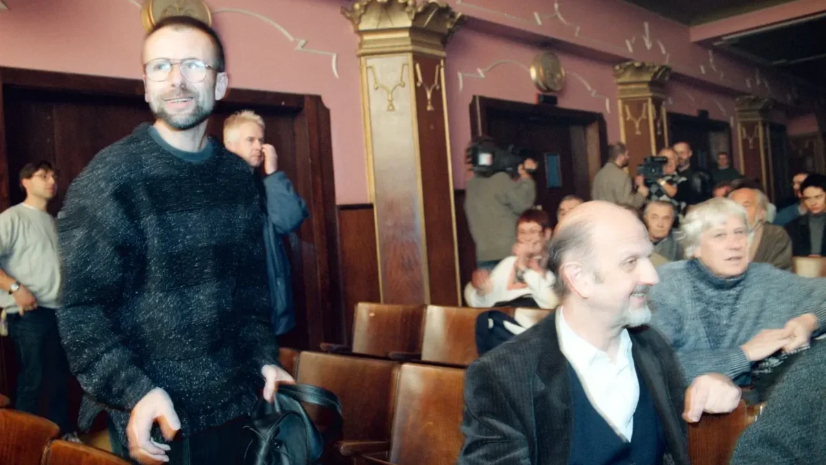 Pavel Koutecký stojí v uličce.