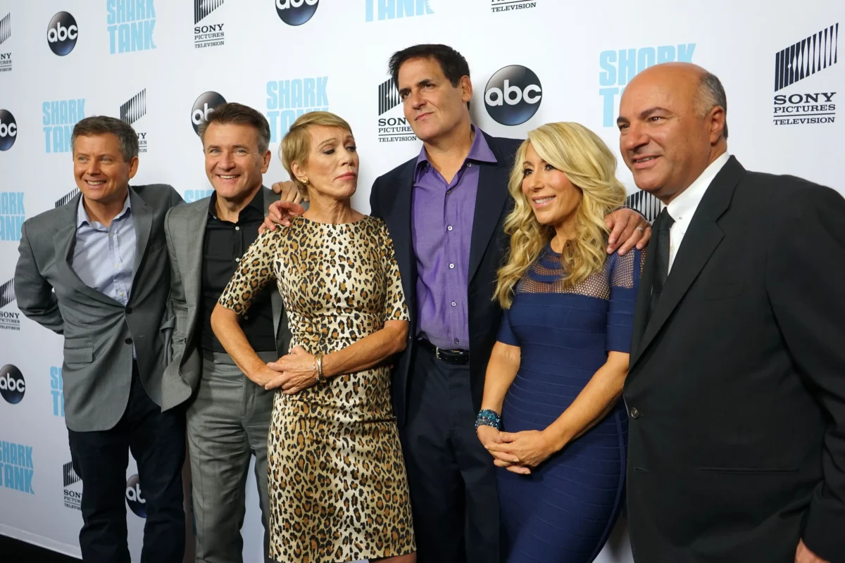 shutterstock_502801996 1 | TVGURU.cz Six adults in formal attire posing together on a red-carpet backdrop with Shark Tank and ABC logos visible.
