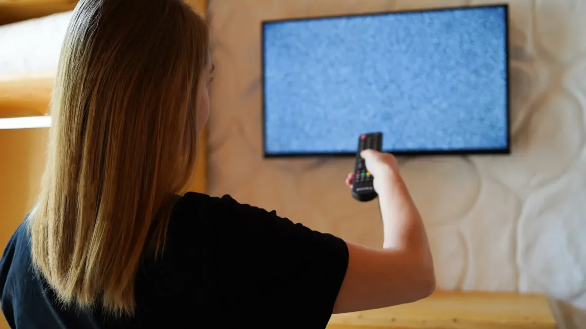 žena zapíná televizi, která nemá signál