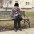 seniorka v klobouku s holí sedící na lavičce