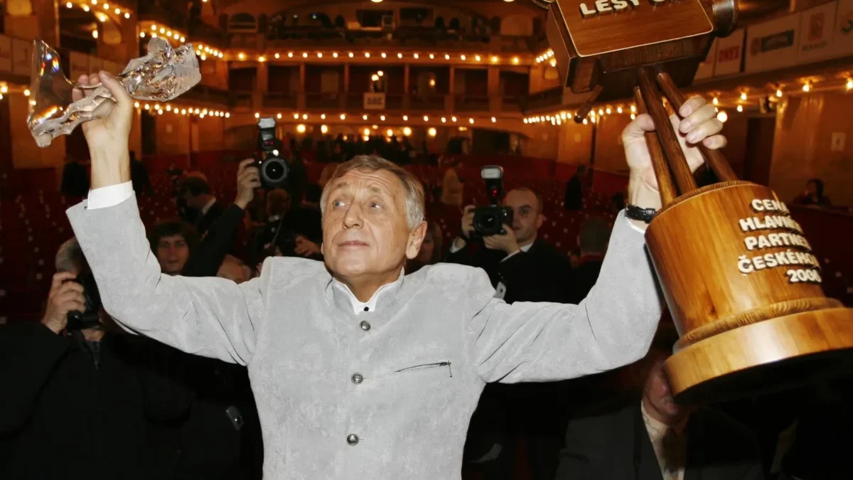 Jiří Menzel na vyhlášení cen VAc drží nad hlavou dřevěnou a křišťálovou cenu