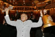 Jiří Menzel na vyhlášení cen VAc drží nad hlavou dřevěnou a křišťálovou cenu